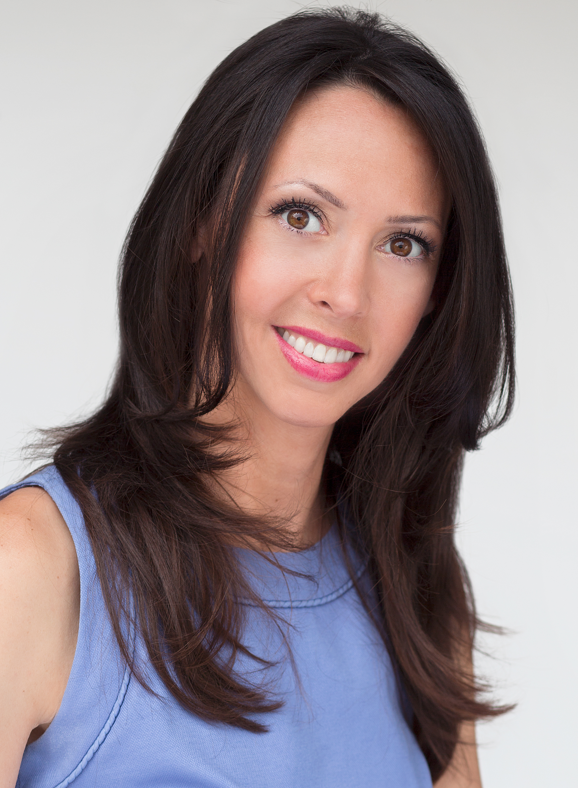 Tammy Gold, LCSW, photographed in a blue sleeveless top against a pale studio background.